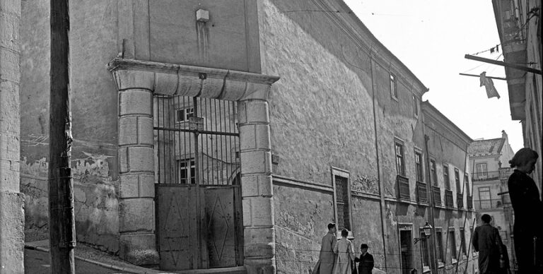 Palácio Alarcão [c. 1952] Portão seiscentista — na esquina da Rua das Gaivotas, n.º 2, para a Rua Fernandes Tomás — de grossas colunas e verga abauladas e cunhais de cantaria, sólidos. Salvador de Almeida Fernandes, in Lisboa de Antigamente